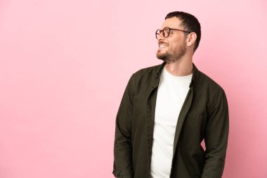 Pembe arka planda izole edilmiş genç Brezilyalı adam.