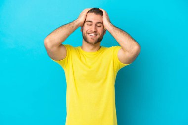 Mavi arka planda izole edilmiş yakışıklı beyaz adam gülüyor.