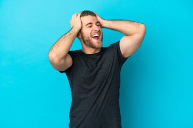 Mavi arka planda izole edilmiş yakışıklı beyaz adam bunalıma girmiş.