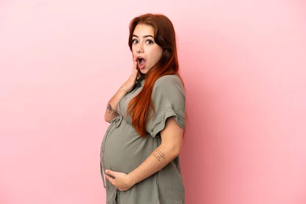 Joven Pelirroja Caucásica Aislada Sobre Fondo Rosa Embarazada Haciendo Gesto — Foto de Stock