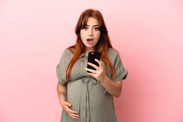 Jonge Roodharige Blanke Vrouw Geïsoleerd Roze Achtergrond Zwanger Met Behulp — Stockfoto
