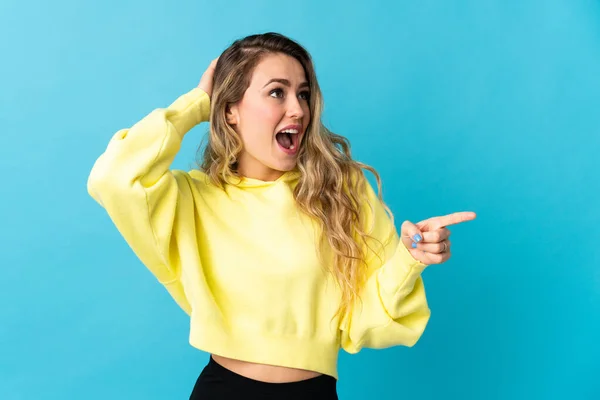 Young Brazilian Woman Isolated Blue Background Surprised Pointing Finger Side — Stockfoto