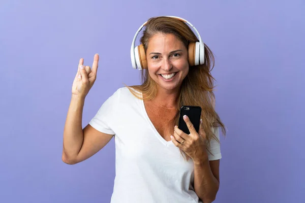 Middle Age Brazilian Woman Isolated Purple Background Listening Music Mobile — Fotografia de Stock