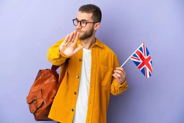 Young Caucasian Man Holding United Kingdom Flag Isolated Purple Background — стоковое фото