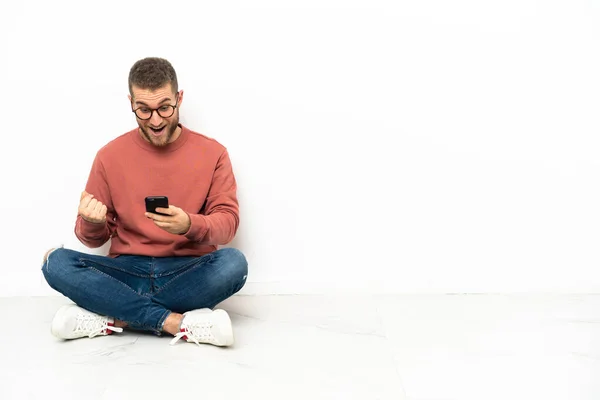 Young Handsome Man Sitting Floor Surprised Sending Message — Stock Photo, Image