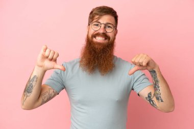 Kırmızımsı beyaz adam pembe arka planda soyutlanmış gururlu ve kendini beğenmiş.