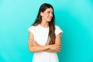 Mavi arka planda izole edilmiş beyaz bir kadın. Taraf ararken şüphe duyuyor.