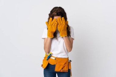 Genç elektrikçi, yorgun ve hasta bir ifadeyle beyaz arka planda izole edilmiş.