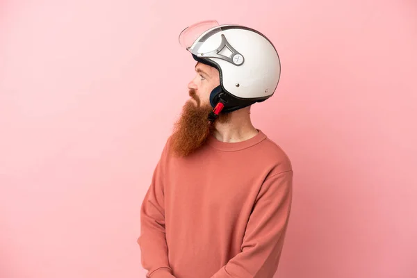 Young Reddish Caucasian Man Motorcycle Helmet Isolated Pink Background Looking — Zdjęcie stockowe