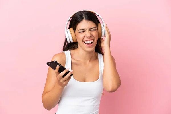 Giovane Donna Caucasica Isolata Sfondo Rosa Ascoltare Musica Con Cellulare — Foto Stock