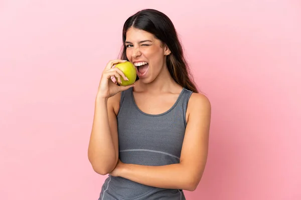 Pembe Arka Planda Izole Edilmiş Beyaz Bir Kadın Elma Yiyor — Stok fotoğraf