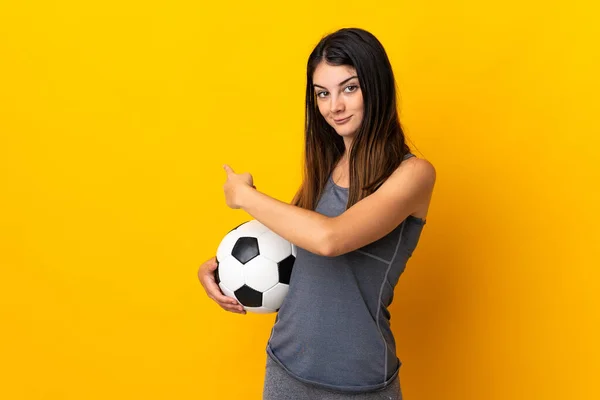 Young Football Player Woman Isolated Yellow Background Pointing Back — Zdjęcie stockowe