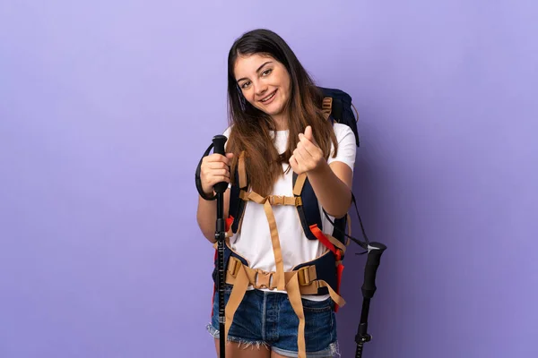 Young Woman Backpack Trekking Poles Isolated Purple Background Making Money — Stock Photo, Image