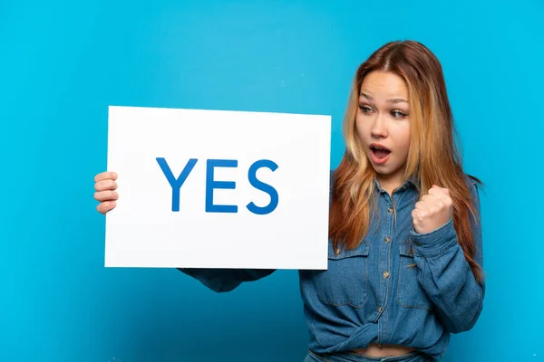 Teenager Girl Isolated Blue Background Holding Placard Text Yes Celebration — Zdjęcie stockowe
