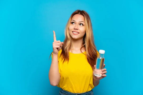 Adolescente Chica Con Una Botella Agua Sobre Fondo Azul Aislado —  Fotos de Stock
