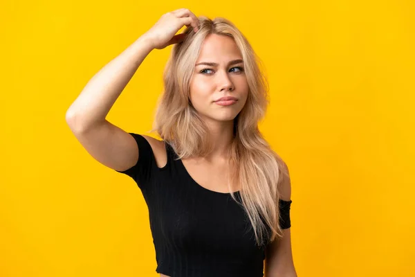 Νεαρή Ρωσίδα Απομονωμένη Κίτρινο Φόντο Έχοντας Αμφιβολίες Ενώ Ξύνει Κεφάλι — Φωτογραφία Αρχείου