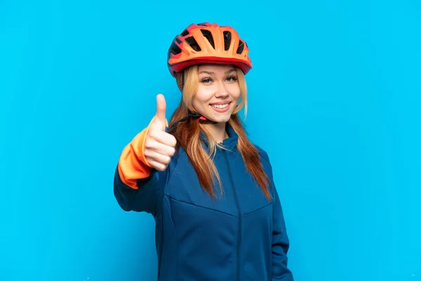 Молодая Девушка Велосипедистка Изолирована Синем Фоне Большими Пальцами Вверх Потому — стоковое фото