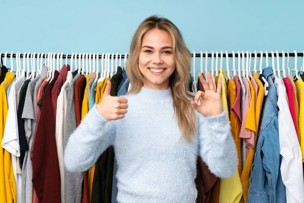 Adolescente Ragazza Russa Comprare Alcuni Vestiti Isolati Sfondo Blu Mostrando — Foto Stock