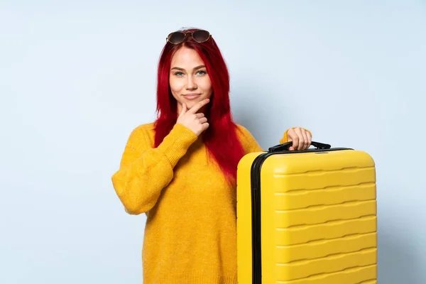 带着一个蓝色背景的行李箱的旅行女孩 — 图库照片