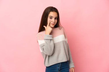 Pembe arka planda izole edilmiş küçük kız bir şey gösteriyor