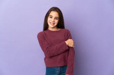 Mor arka planda yalnız küçük kız gülüyor.