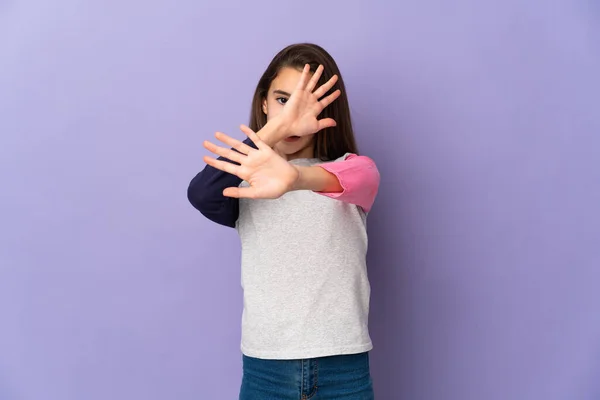 紫の背景に孤立した少女前に手を伸ばし緊張 — ストック写真