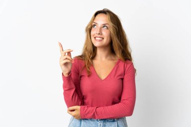 Mavi arka planda izole edilmiş genç sarışın kadın harika bir fikre işaret ediyor.