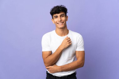 Arjantinli genç adam arka planda yalnız gülüyor.