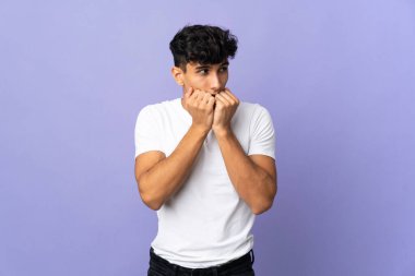 Young Argentinian man isolated on background nervous and scared putting hands to mouth