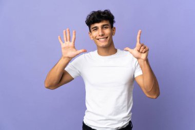 Young Argentinian man isolated on background counting seven with fingers