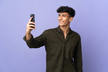Young Argentinian man isolated on background making a selfie