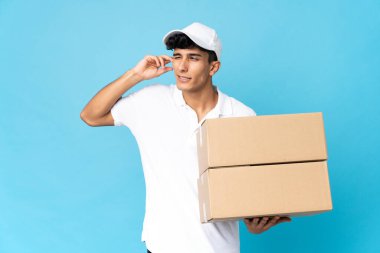 Delivery Argentinian man isolated on blue background frustrated and covering ears