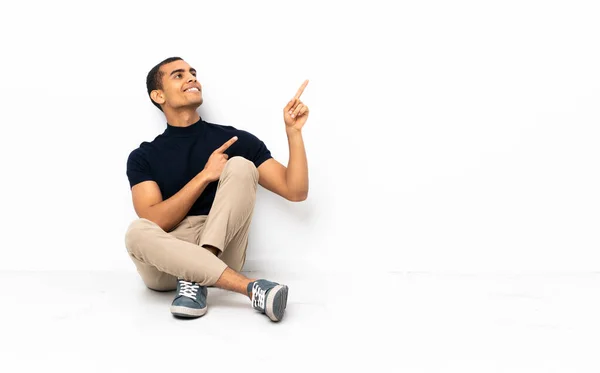 African American Man Sitting Floor Pointing Index Finger Great Idea — Stock Fotó