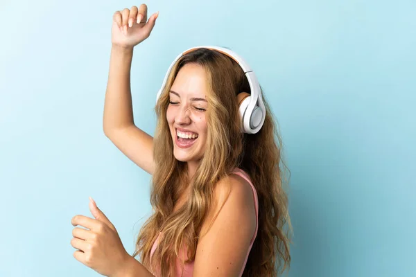 Νεαρή Ξανθιά Γυναίκα Απομονωμένη Μπλε Φόντο Ακούγοντας Μουσική Και Χορεύοντας — Φωτογραφία Αρχείου