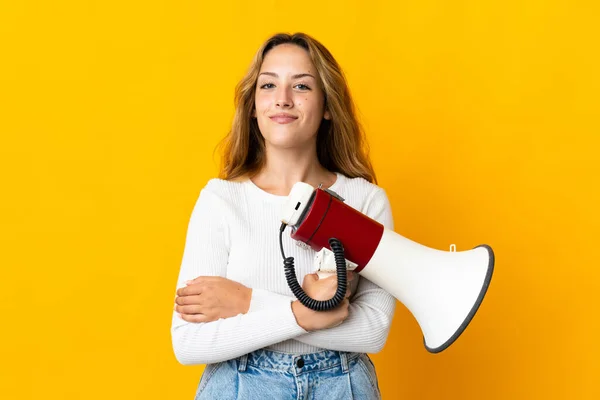 Jonge Blonde Vrouw Geïsoleerd Gele Achtergrond Met Een Megafoon Glimlachen — Stockfoto