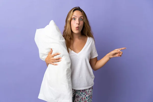 Young Blonde Woman Isolated Purple Background Pajamas Surprised While Pointing — 스톡 사진