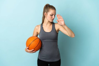 Mavi arka planda basketbol oynayan genç bir kadın dur hareketi yapıyor ve hayal kırıklığına uğruyor.