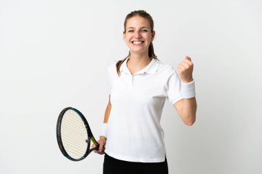 Beyaz arka planda izole edilmiş genç beyaz kadın tenis oynuyor ve zaferi kutluyor.