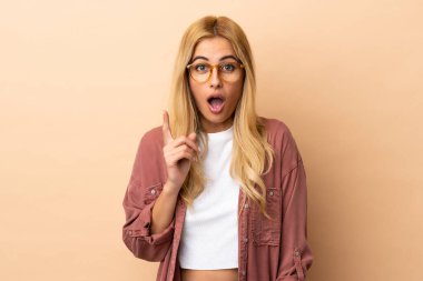 Genç Uruguaylı sarışın kadın izole edilmiş arka planda bir fikir düşünüyor.