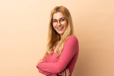 Sarışın genç Uruguaylı kadın kollarını kavuşturup ileriye bakıyor.