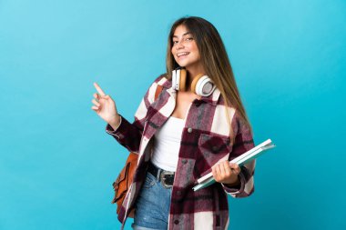 Mavi arka planda izole edilmiş genç bir bayan parmak kenarı işaret ediyor.