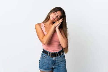 Beyaz arka planda izole edilmiş genç beyaz kadın uyku jesti yapıyor.