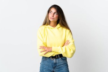 Beyaz arka planda izole edilmiş genç beyaz kadın yan tarafa bakıyor.