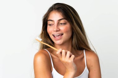 Beyaz arka planda diş fırçası ve mutlu bir ifadeyle izole edilmiş beyaz bir beyaz kadın.