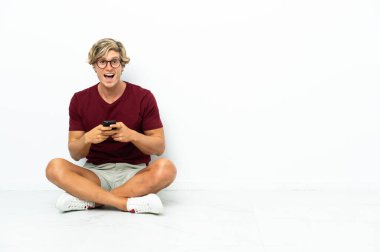 Yerde oturan genç İngiliz şaşırdı ve bir mesaj gönderiyor.