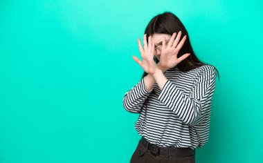 Genç Rus kadın yeşil arka planda izole edilmiş gergin eller öne doğru uzanıyor.