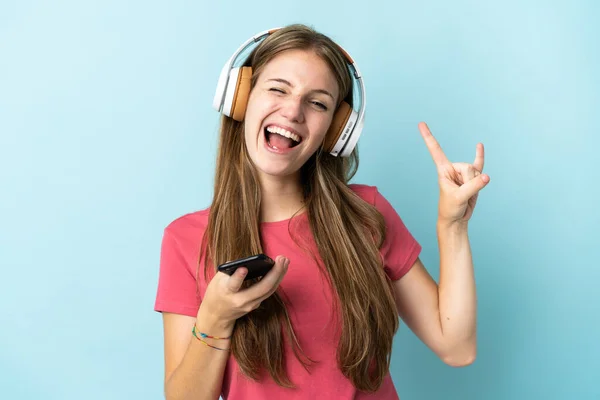 Νεαρή Καυκάσια Γυναίκα Απομονωμένη Μπλε Φόντο Ακούγοντας Μουσική Μια Κινητή — Φωτογραφία Αρχείου