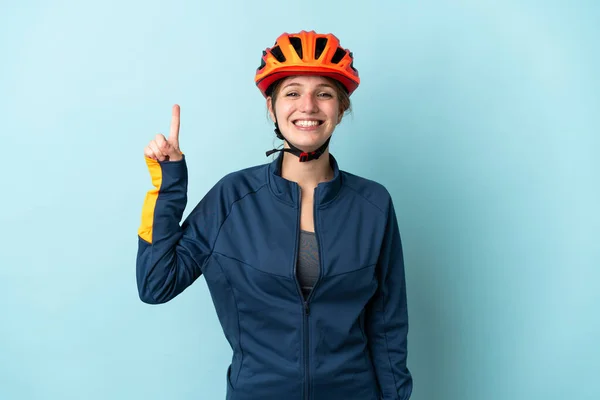 Молодая Женщина Велосипедистка Изолированная Синем Фоне Указывает Отличную Идею — стоковое фото