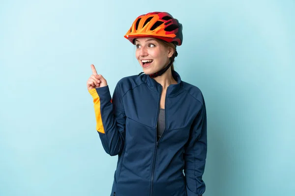 Mavi Arka Planda Izole Edilmiş Genç Bisikletçi Kadın Parmağını Kaldırarak — Stok fotoğraf