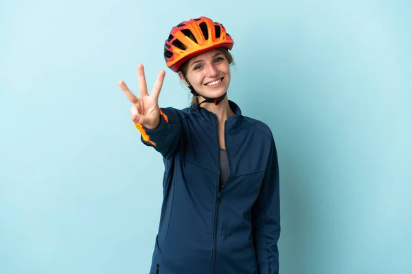 Молодая Женщина Велосипедистка Голубом Фоне Счастлива Считает Троих Пальцами — стоковое фото